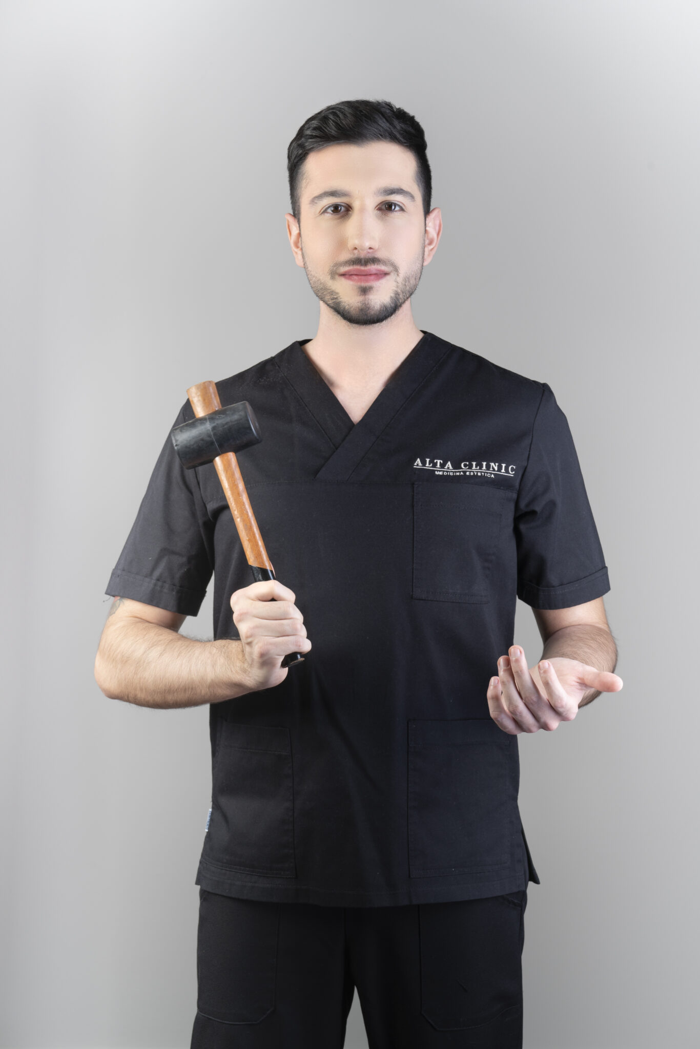 Delor De Ferrabonc, osteopata di Alta Clinic Bergamo, in divisa nera con un martelletto di legno in mano