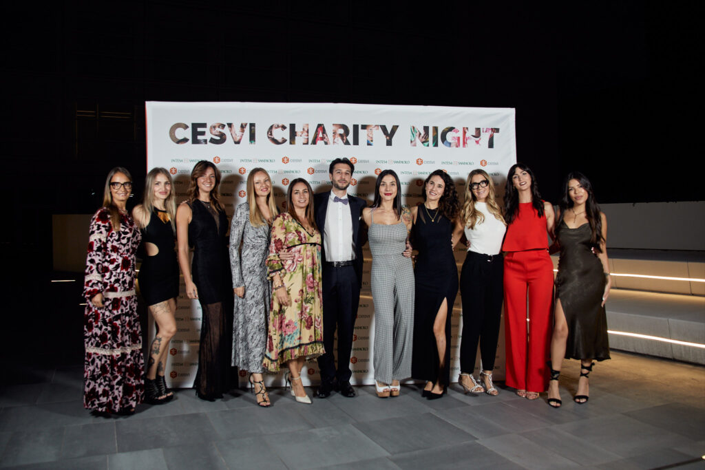 Gruppo di ospiti in posa davanti alla scritta Cesvi Charity Night alla serata benefica 2023 con Alta Clinic