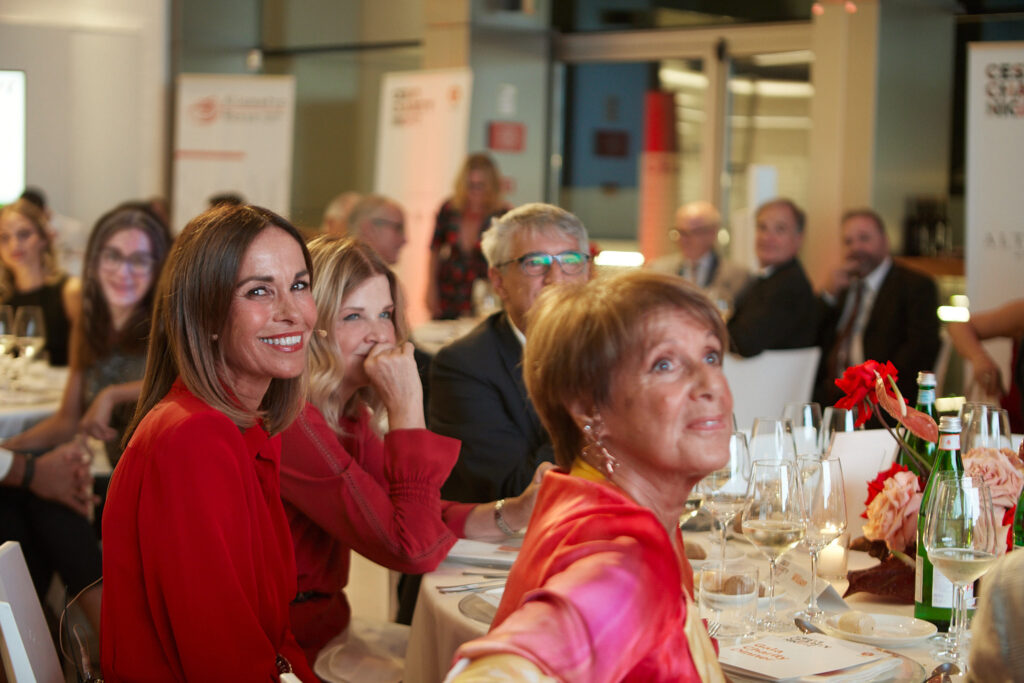 Invitate sorridenti sedute al tavolo della cena di beneficenza Cesvi Charity Night 2022 con la partecipazione di Alta Clinic