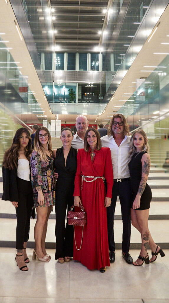 Gruppo di ospiti eleganti in posa nella hall illuminata della Cesvi Charity Night 2022 insieme ad Alta Clinic
